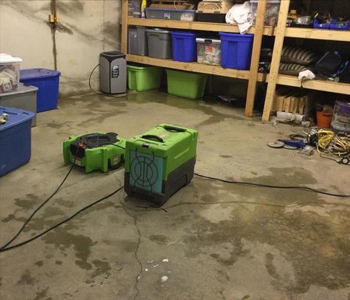 The same portion of the garage but now there is SERVPRO drying equipment in it