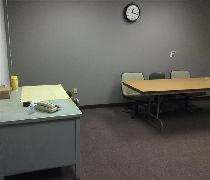 A conference room in a commercial building where the carpet is soaking wet. 