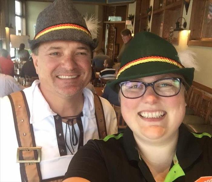 Two SERVPRO employees are taking a selfie wearing Oktoberfest outfits