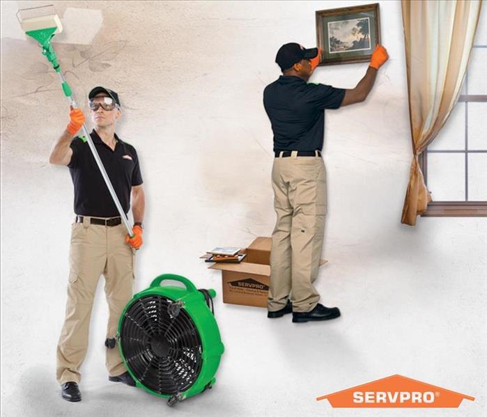 Two SERVPRO employees cleaning soot off walls
