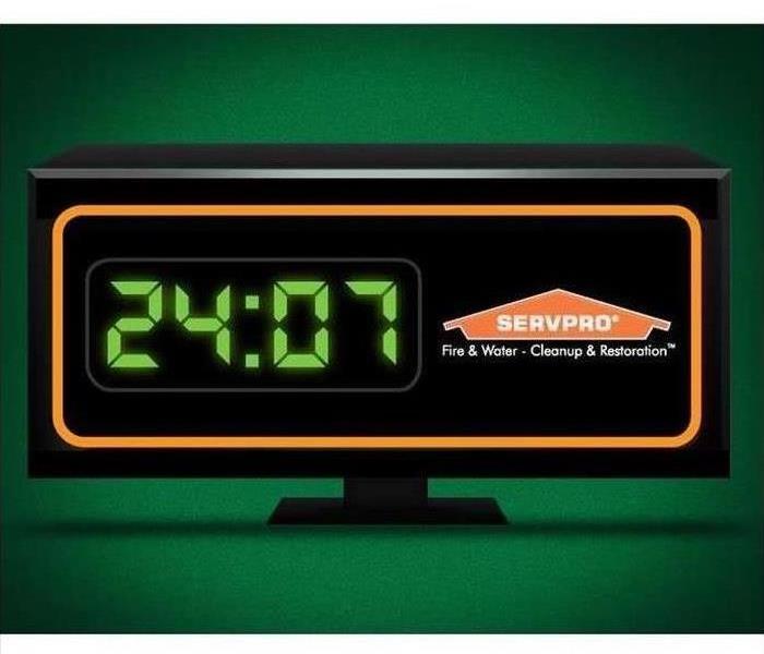 Digital clock w/SERVPRO logo in front of green backgroud